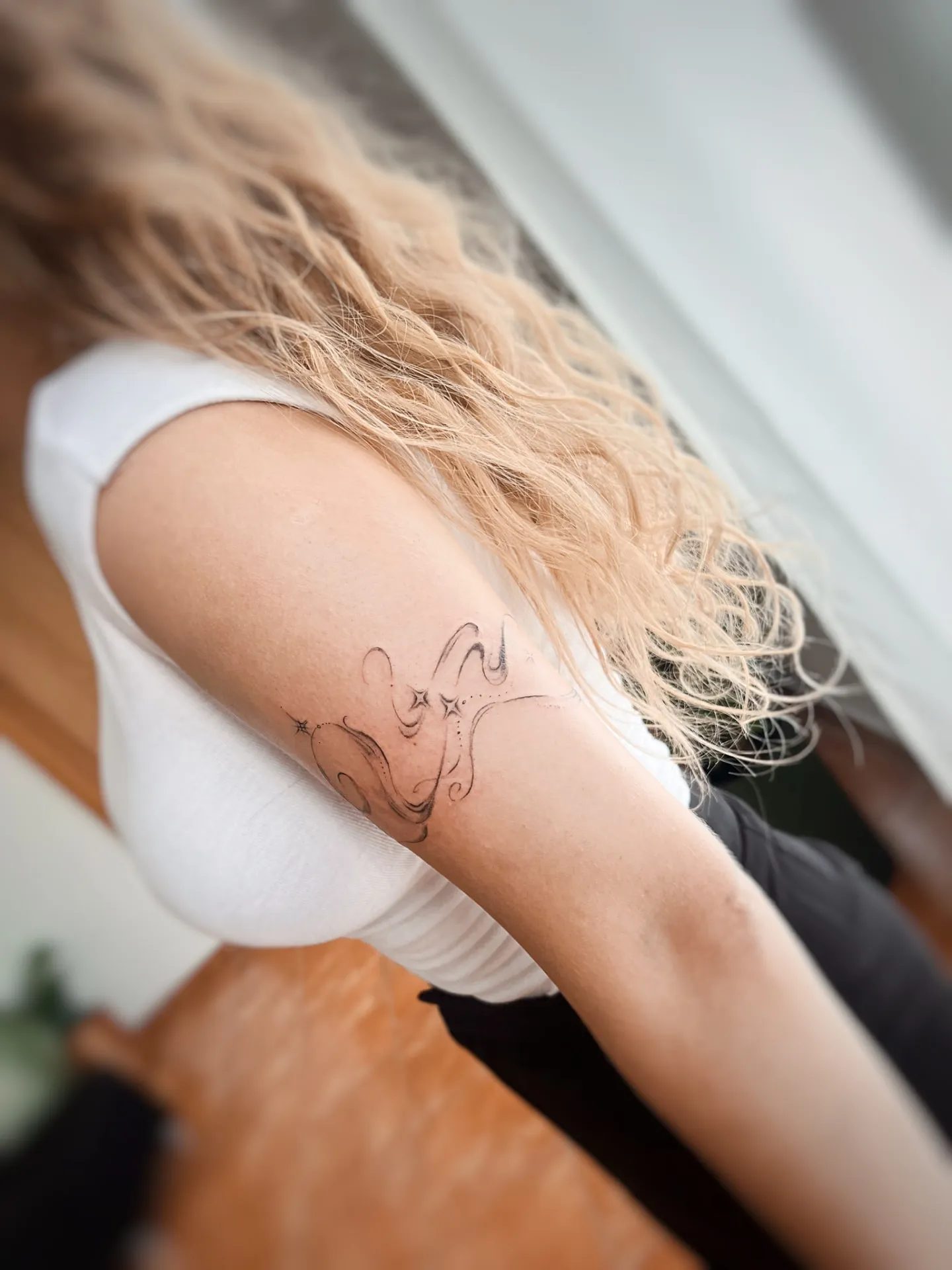 Ornamentální fine-line motiv s hvězdami na paži